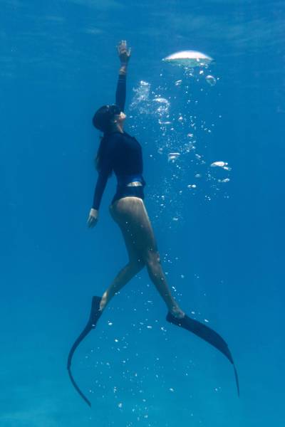woman-freediving-with-flippers-underwater